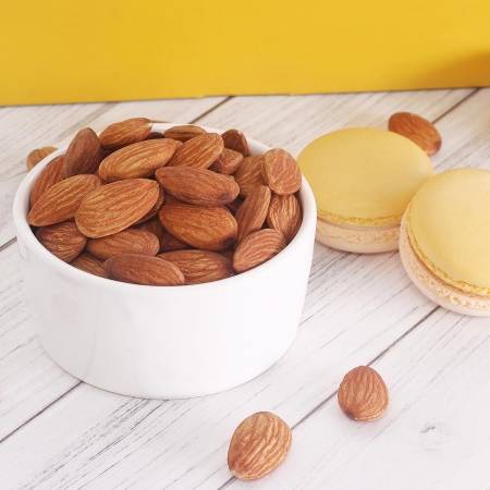 Badem dolu küçük kase ve iki limon aromalı makaronlar, geleneksel Türk lokumu görüntüsü.